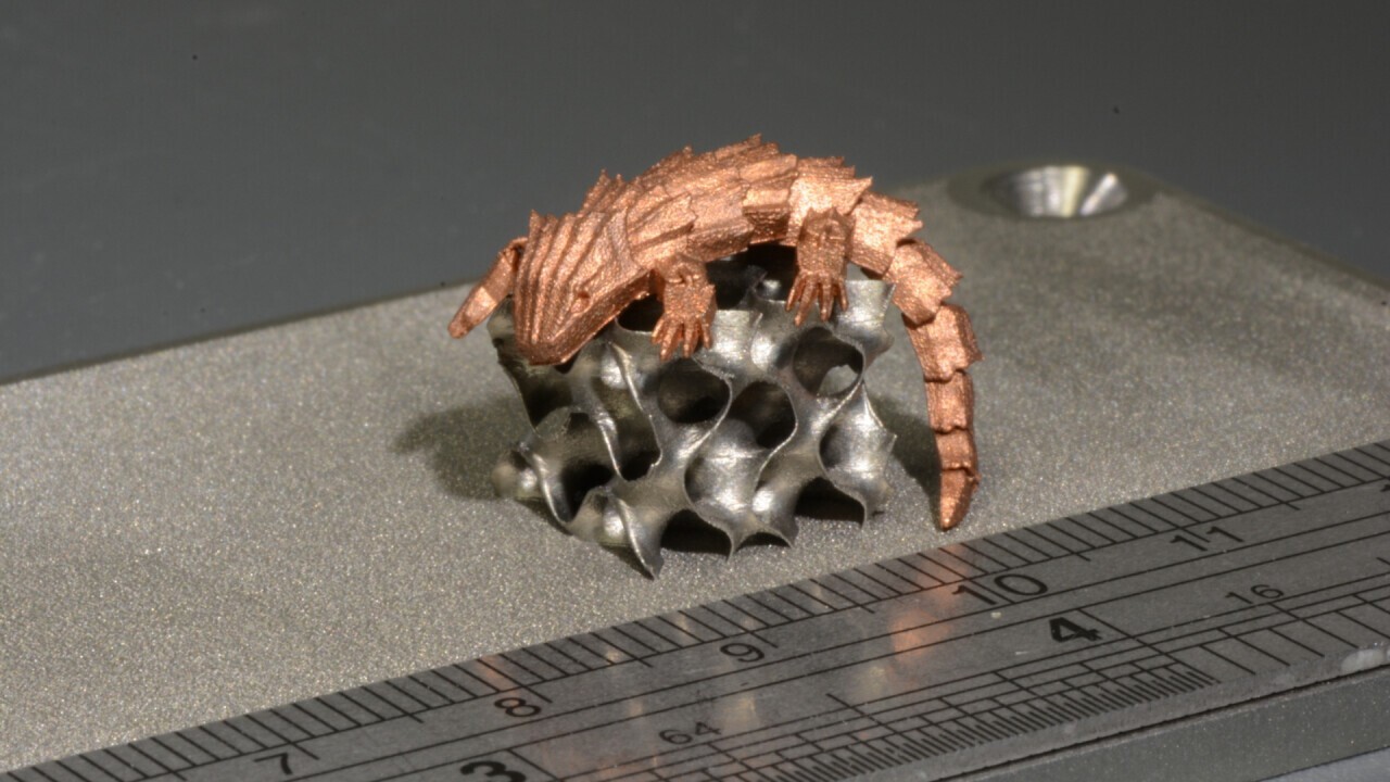 Movable lizard made of pure copper (99.95 %) on a gyroid infill structure made of stainless steel.