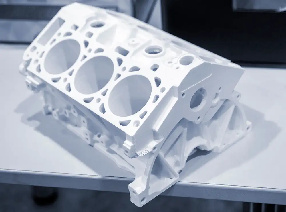 Ein 3D-gedrucktes Modell eines Motorblocks aus weißem Kunststoff.