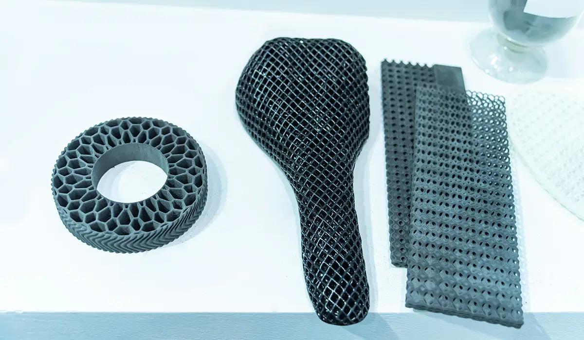 A 3D printed bicycle saddle with a complex, mesh-like pattern. The saddle is designed to be lightweight and ventilated, indicating an innovative design for comfort and breathability.