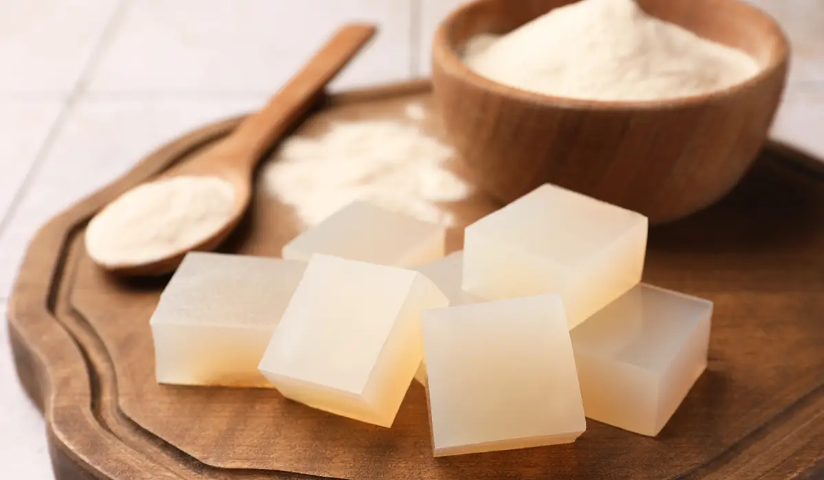 Agar-agar cubes and agar powder on a wooden board.